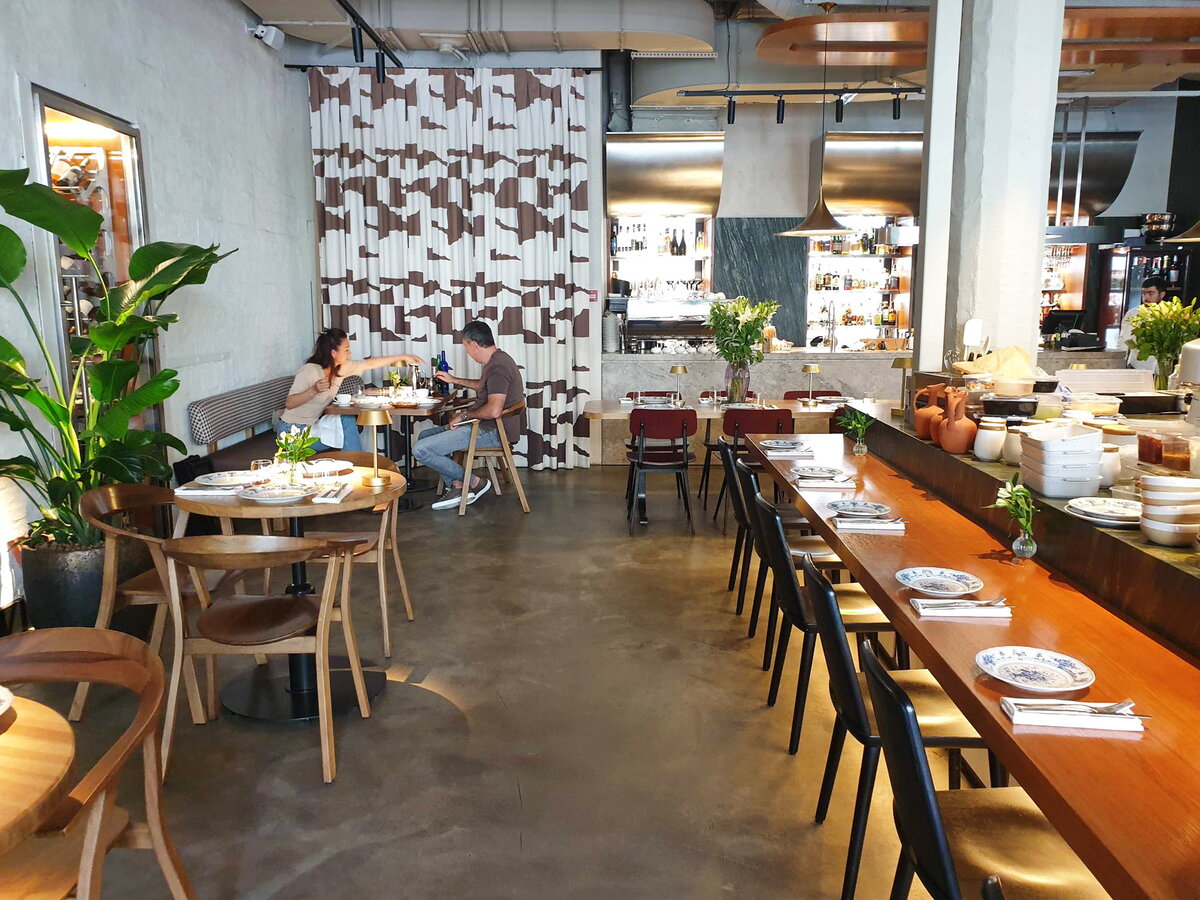 Справа стол-стойка вдоль открытой кухни