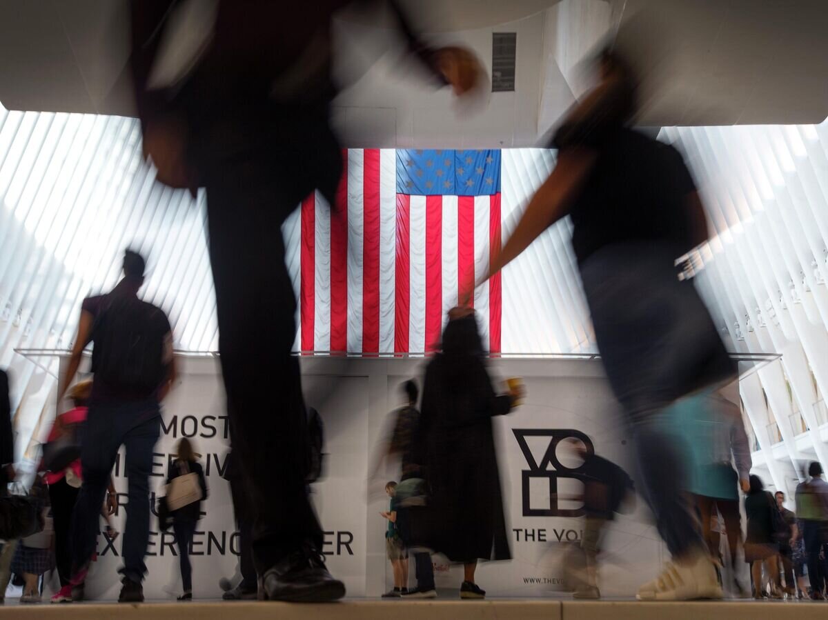 Люди идут мимо флага США в Нью-Йорке© AP Photo / Wong Maye-E