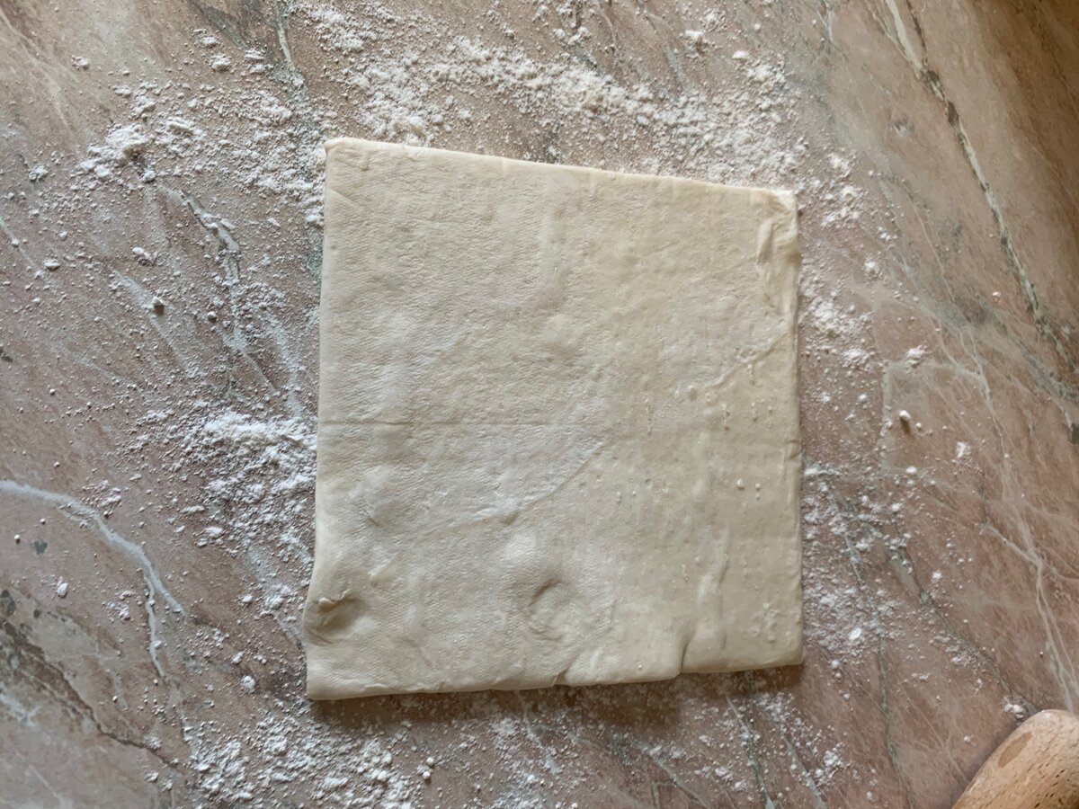 Берём лист слоенного бездрожевого теста и кладём на припыленную мукой поверхность