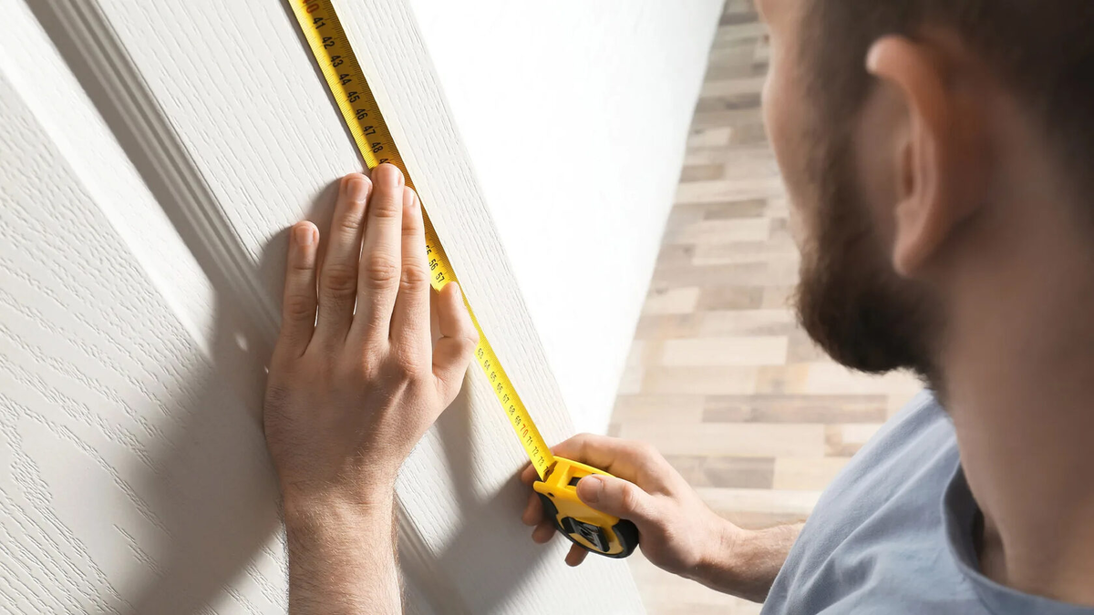 Человек с измерительным прибором. Измерение рулеткой. Замер кухни. Человек с линейкой. Ремонт измерит.
