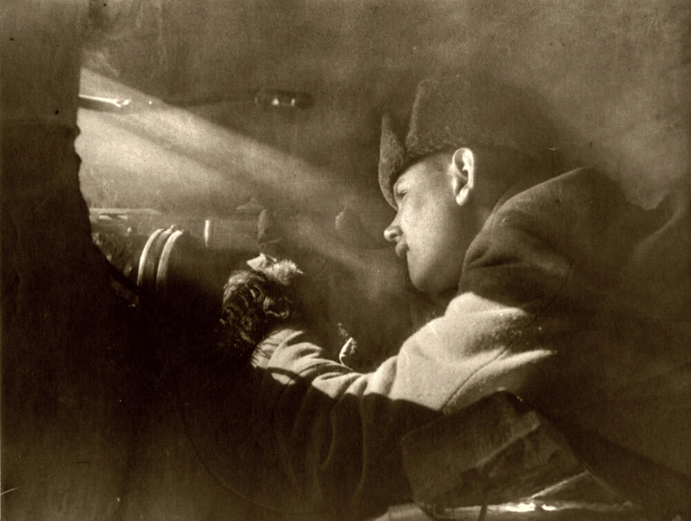 Красноармеец ведет огонь из пистолета-пулемета ППШ через пролом в стене здания в Сталинграде. 1942 г.