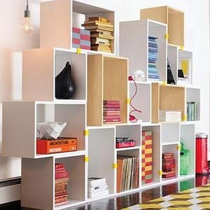 Мебель из картона выглядит совершенно как обычная мебель – например, на фото справа вы видите стеллаж из обычных картонных коробок, вставленных одна в другую, оклеенных на торцах бумажным скотчем и покрашенных водостойкой краской в белый цвет. Этот стеллаж обошелся хозяевам в стоимость литровой банки краски, а выглядит очень достойно. Как видите, если хорошо прокрасить картон, то мебель становится вполне водоотталкивающей и можно ставить сколь угодно много ваз с цветами.