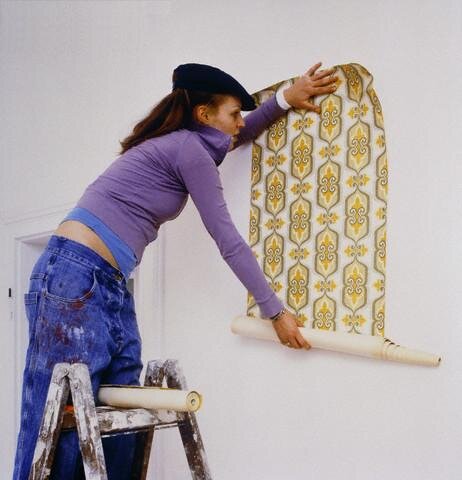 Young Woman Putting Up Wallpaper — Image by © Holger Winkler/Corbis