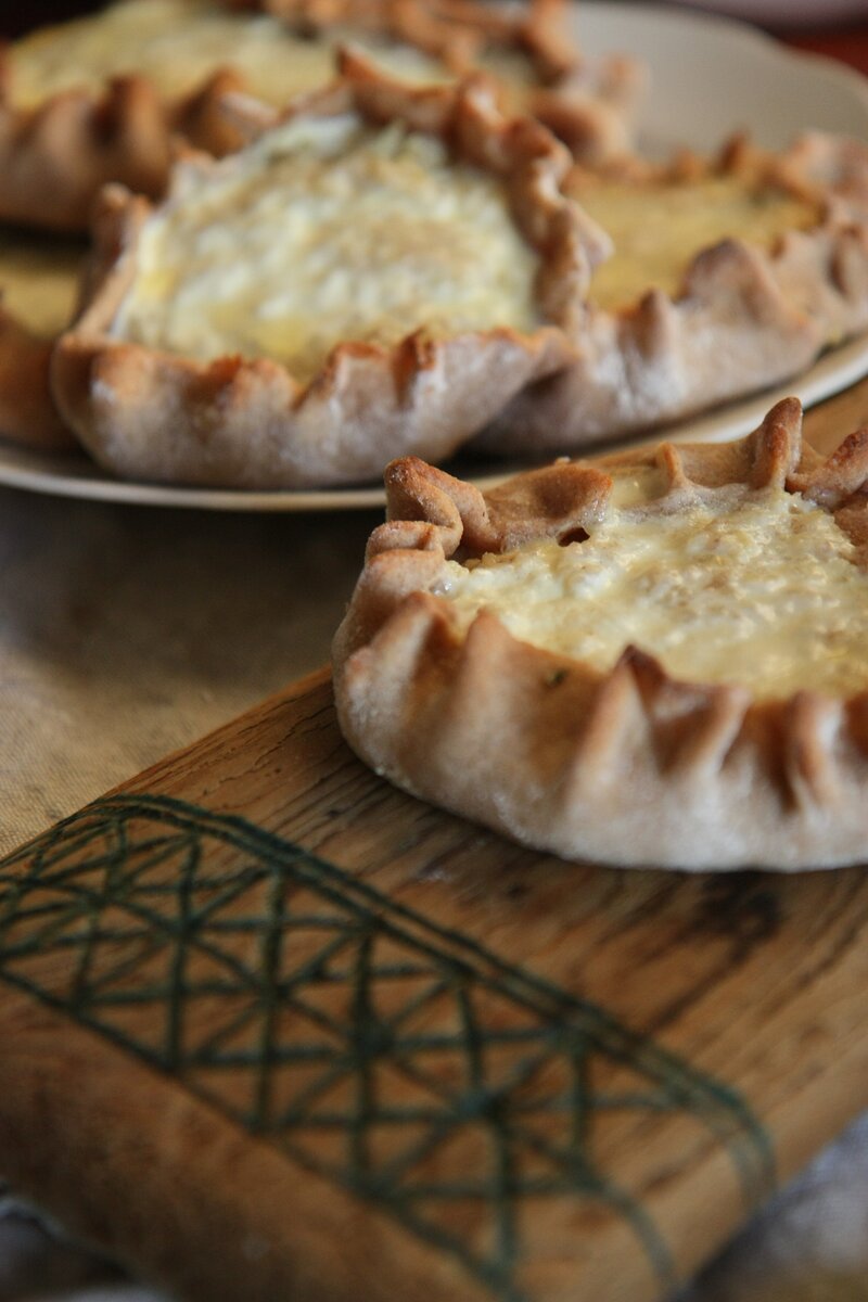 Скорее всего, люди, живущие ближе к Карелии, опознают эти открытые пирожки из ржаной муки  как национальное карельское блюдо - калитки, а живущие ближе к коми - как национальное титульное коми блюдо - шаньги. Так или иначе - это древнее финно-угорское блюдо, и общих черт у калиток и шанег больше, чем различий. Лично я считаю, что на всей территории Русского Севера это блюдо в разных вариациях распространилось скорее не от соседей - карелов и коми, а от прямых предков северян - чуди заволочьской, аборигенных финно-угорских племен, населявших эту территорию до прихода новгородцев. Чудь ассимилировались с русскими, переняв их язык и культуру, но оставила свой след в ДНК современных жителей русского севера и, частично, в древних традициях - таких, как заповедные рощи, священные камни и открытые пирожки из ржаной муки. 