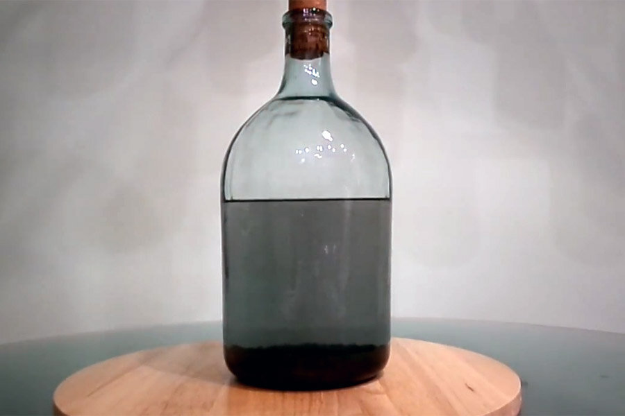 признаком завершившейся очистки является выпадение осадка из фрагментов угля с сивушными маслами;Вид самогона после 5-7 дней отстаивания после кокосового угля