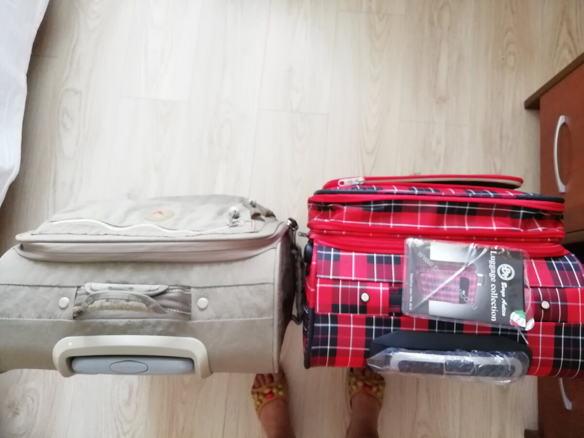 Не очень удачный ракурс для пояснения, но скажу просто: слева - мой любимый и долгоиграющий чемодан фирмы Roncato, с которым мне пришлось таки расстаться. Справа - новый, купленный на замену серенькому. Оба они матерчатые. И у серого была особенность конструкции - он всегда стоял под наклоном (как бы он не был сильно наполнен) относительно вертикали и никогда не падал, да и по весу он был немного легче. А вот клетчатый имеет возможность дополнительно объёма (расширения), и как только в него положишь больше вещей, он это мгновенно "чувствует" и начинает заваливаться вперёд. И чтобы он стоял, приходится разворачивать передние и задние колёса в разные стороны друг от друга, чтобы придать чемодану устойчивость. Вот такой минус обнаружила. В то же время, у клетчатого чемодана съёмные колёса, в отличие от Roncato.  