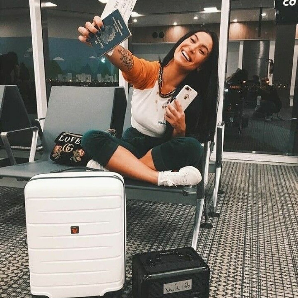 Девушка с чемоданом в аэропорту